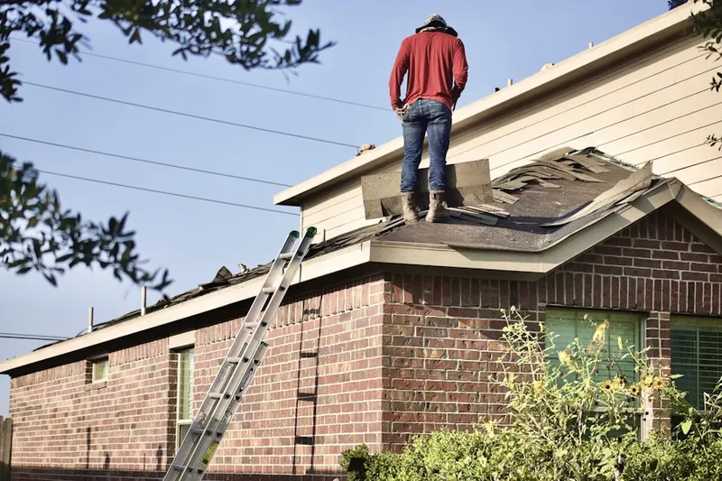 Professional roofer working on a residential roof in Glenwood Landing